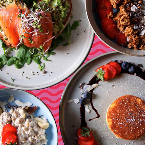 Verschiedene Frühstücksvarianten für das weihnachtliche Frühstücksbuffet. Man sieht hier unter anderem Pancakes, eine Avocado-Stulle und Müsli.