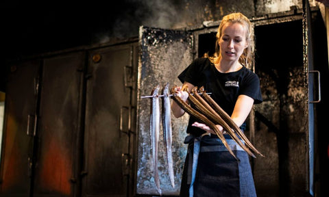 Geräucherte Aale an Spießen vor Räucherofen –Jenny von Aal Hoffmann zeigt die traditionelle Fischräucherei Hoffmann.