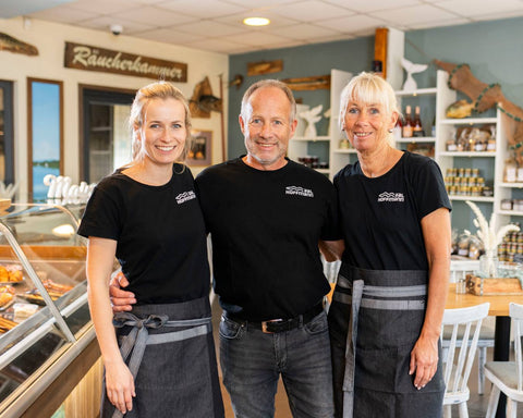 Marc, Andrea und Jenny Hoffmann stehen im Fischladen der Räucherei Hoffmann am Dümmer-See.