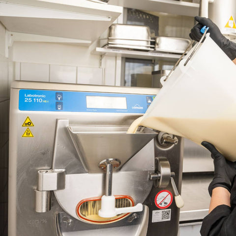 Frischer Eismix wird in die Eismaschine gefüllt. Frisch aus der Maschine - direkt in die Eistheke beim Eiscafe Hoffmann am Dümmer-See.