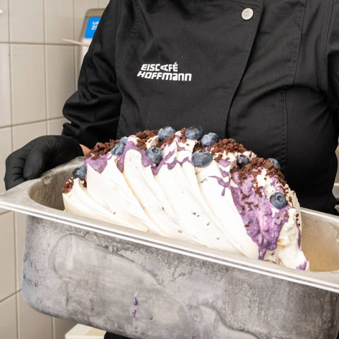 Eismacherin beim Eiscafe Hoffmann mit frischem Berry Cheesecake Eis.