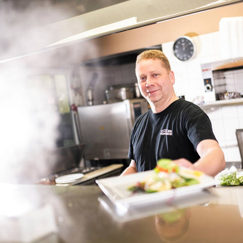 Koch arbeitet in der offenen Küche im Fischhaus Hoffmann am Dümmer-See.