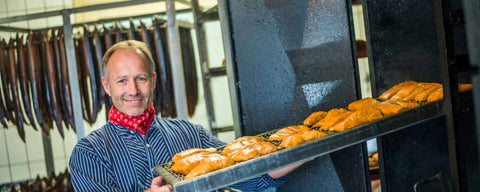 Räucherfisch aus dem Altonaer Ofen. Marc Hoffmann hält Rost mit Stremellachs in der Räucherei am Dümmer-See.